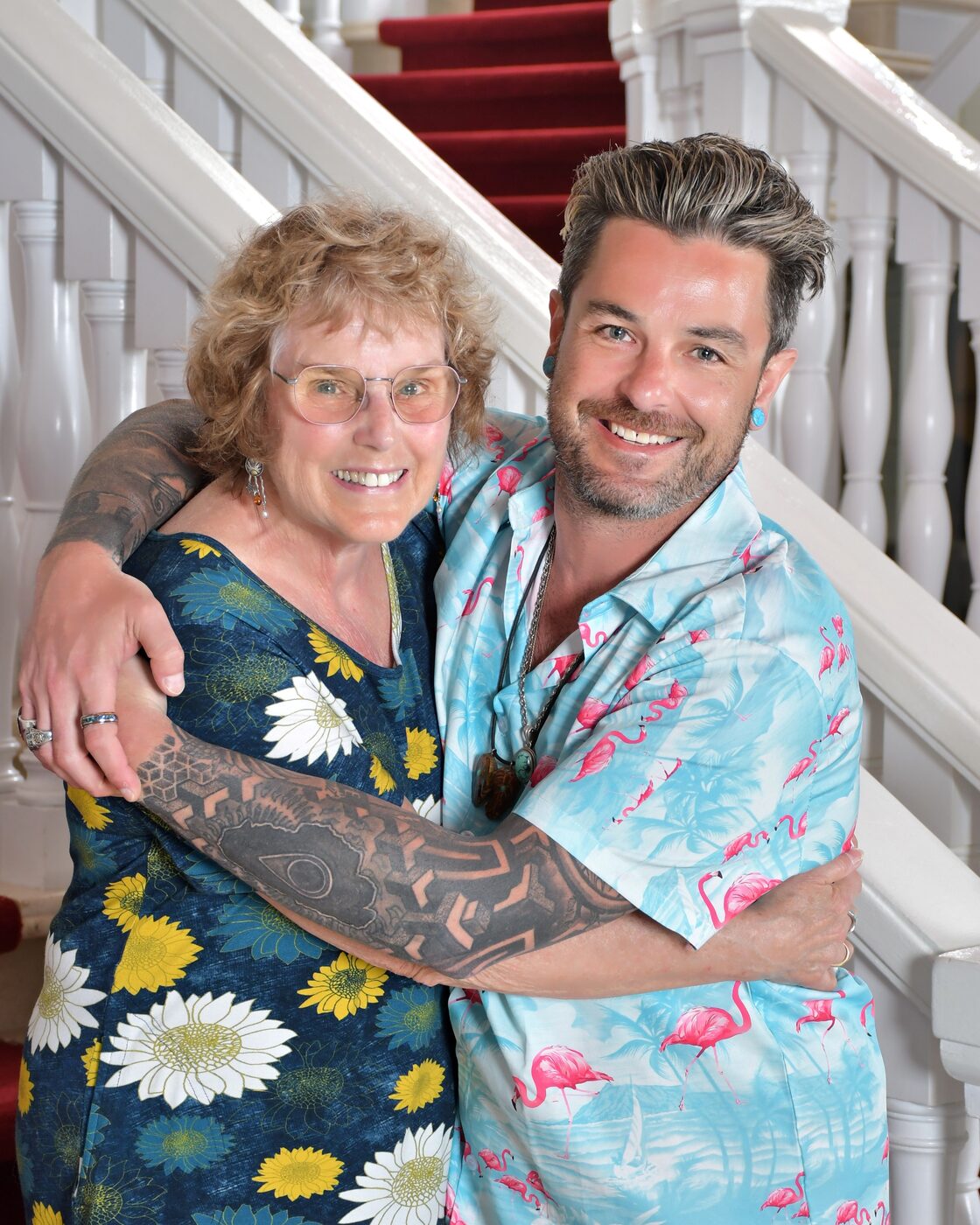 Woman and man in a pink floral shirt on the staircase