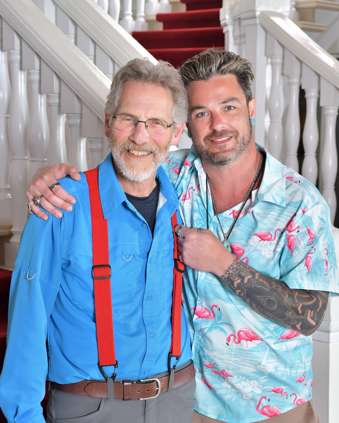 Two men, one in red suspenders, on the grand staircase