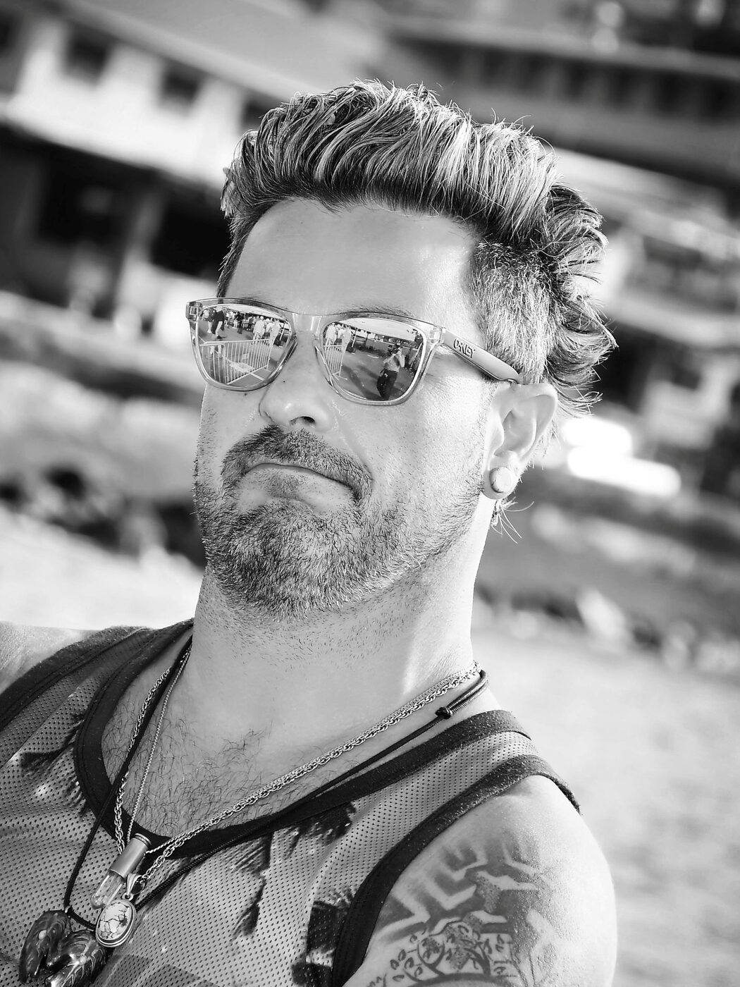 Black and white portrait of a man in sunglasses on a beach