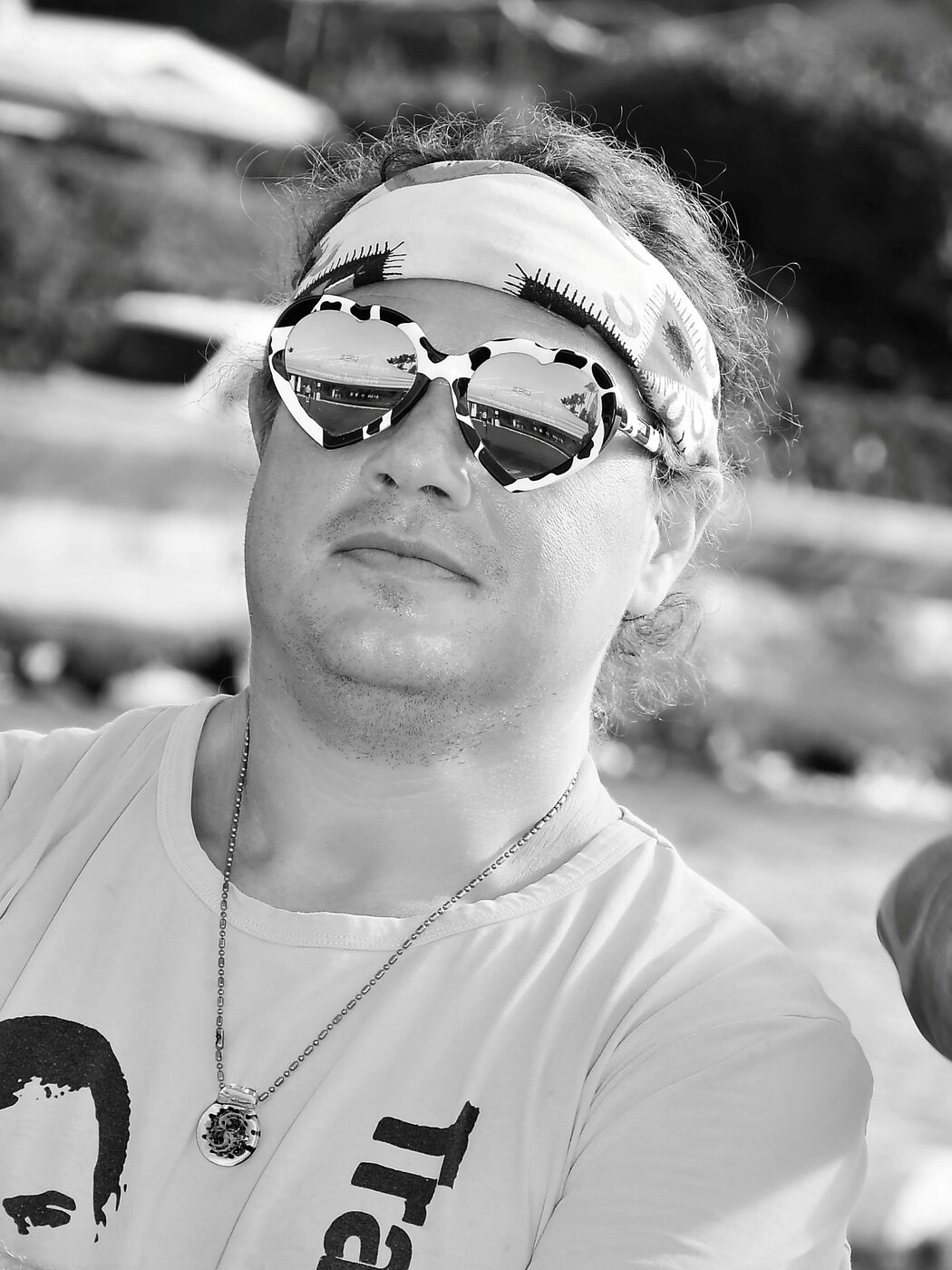 Black and white candid of a man in a bandana and sunglasses