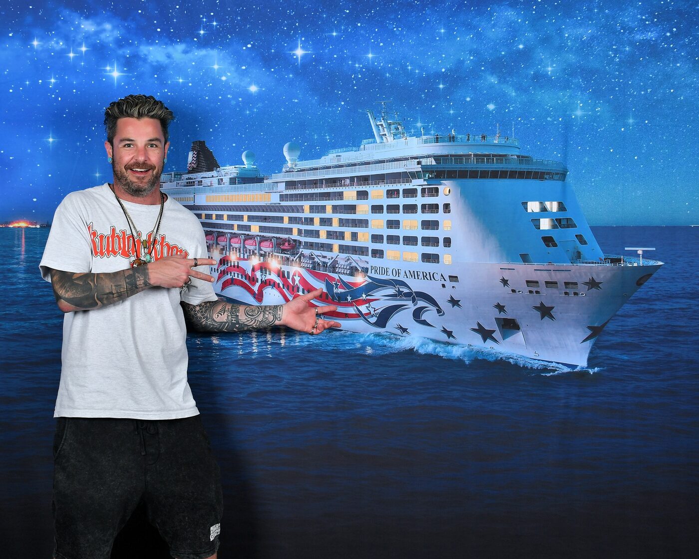 Man posing with a night-sky backdrop of the Pride of America